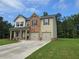 Two-story home featuring a brick and vinyl exterior, a two-car garage, and a well-manicured front lawn at 1594 Sungrown Way, Mcdonough, GA 30253