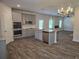 Modern kitchen features stainless appliances, granite countertops, and spacious island with stylish gray cabinetry at 1594 Sungrown Way, Mcdonough, GA 30253