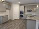 Well-lit kitchen features stainless appliances and light gray cabinets with granite countertops at 1594 Sungrown Way, Mcdonough, GA 30253