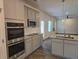 Bright, open kitchen features stainless appliances, granite countertops and modern gray cabinetry at 1594 Sungrown Way, Mcdonough, GA 30253