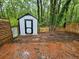 Backyard with a brick patio, shed, and wooden fences in a wooded area at 200 Williamsburg Way, Fayetteville, GA 30214