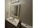 Bathroom sink with gray vanity, framed mirror, light fixture, and closed toilet at 200 Williamsburg Way, Fayetteville, GA 30214