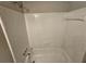 A full white tile bathtub and shower combo with a shower head and clear knobs at 200 Williamsburg Way, Fayetteville, GA 30214