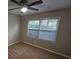 This bedroom has plush carpet, a ceiling fan, and a window overlooking the neighborhood at 200 Williamsburg Way, Fayetteville, GA 30214