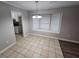 Open dining room with tile flooring, a bright window seat, and a view into the adjacent, updated kitchen at 200 Williamsburg Way, Fayetteville, GA 30214