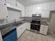 Modern kitchen featuring stainless steel appliances, granite countertops, and classic white cabinets and tile flooring at 200 Williamsburg Way, Fayetteville, GA 30214