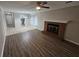 Spacious living area with fireplace and wood flooring; the design merges seamlessly with a tiled dining space at 200 Williamsburg Way, Fayetteville, GA 30214