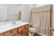 Clean bathroom featuring a shower with decorative curtain, a vanity with sink, and a toilet at 823 Mackay Crk, Woodstock, GA 30188