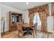 Dining room with hardwood floors, a table with four chairs, and decorative curtains at 823 Mackay Crk, Woodstock, GA 30188