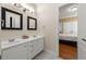Bathroom featuring a double vanity with framed mirrors, white cabinets, and tiled floors, as well as a bedroom view at 1159 Thornwell Ne Dr, Brookhaven, GA 30319
