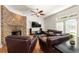 Comfortable living room featuring a stone fireplace, hardwood floors, and stylish leather seating at 1159 Thornwell Ne Dr, Brookhaven, GA 30319