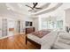 Spacious main bedroom with hardwood floors, a ceiling fan, crown molding, and a door leading to the bathroom at 1159 Thornwell Ne Dr, Brookhaven, GA 30319