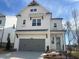 Charming two-story home with white siding, a gray garage door, and a beautifully landscaped front yard at 625 Skytop Dr, Cumming, GA 30040