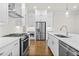 This modern kitchen features stainless appliances, white cabinets, and gorgeous hardwood flooring at 625 Skytop Dr, Cumming, GA 30040