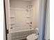 Clean bathroom featuring a bathtub with a shower, built in shelves, and a toilet at 1636 Fuma Leaf Way, Mcdonough, GA 30253