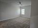 Spacious bedroom with plush carpet, a modern ceiling fan, and a bright window overlooking the outdoor scenery at 1636 Fuma Leaf Way, Mcdonough, GA 30253