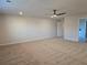 Large carpeted room with a modern ceiling fan, neutral walls, and bright natural light at 1636 Fuma Leaf Way, Mcdonough, GA 30253
