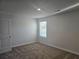 Carpeted bedroom with a window for natural light and a door, offering a cozy retreat at 1636 Fuma Leaf Way, Mcdonough, GA 30253
