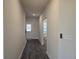 Bright hallway with sleek wood floors, leading to a well-lit bathroom and showcasing a modern interior design at 1636 Fuma Leaf Way, Mcdonough, GA 30253