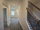 Hallway view leading to living area and staircase with carpet and rod iron railing at 1636 Fuma Leaf Way, Mcdonough, GA 30253