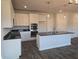Modern kitchen featuring white cabinets, stainless steel appliances, an island, and elegant pendant lighting at 1636 Fuma Leaf Way, Mcdonough, GA 30253