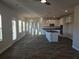 Open-concept living space with lots of windows, hardwood floors, flowing into kitchen area, and pendant lighting at 1636 Fuma Leaf Way, Mcdonough, GA 30253