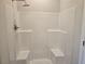 Shower stall with tile surround, shower head, and two bench seats at 1636 Fuma Leaf Way, Mcdonough, GA 30253