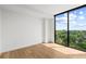 Bright bedroom with hardwood floors and large window overlooking green trees at 2425 Peachtree Ne Rd # 1409, Atlanta, GA 30305