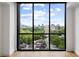 Bedroom offering city views from a large window, complemented by hardwood floors at 2425 Peachtree Ne Rd # 1409, Atlanta, GA 30305