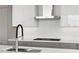 Close up of a modern kitchen with a gas stovetop and stainless steel hood at 2425 Peachtree Ne Rd # 1409, Atlanta, GA 30305