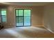 Open living room with neutral carpet and sliding glass door to the deck at 2704 Cumberland Se Ct # 27, Smyrna, GA 30080