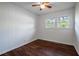A cozy bedroom featuring paneled walls, hardwood floors, and a ceiling fan for a modern and comfortable living space at 80 E Howard St, Kingston, GA 30145
