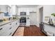 Modern kitchen boasts white cabinets, stainless steel appliances, granite countertops, and hardwood floors, creating a stylish space at 80 E Howard St, Kingston, GA 30145
