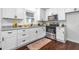 Well-lit kitchen featuring white cabinets, granite countertops, stainless steel appliances, and hardwood floors at 80 E Howard St, Kingston, GA 30145