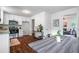 Open-concept kitchen and dining area featuring white cabinetry, stainless steel appliances, and hardwood floors at 80 E Howard St, Kingston, GA 30145