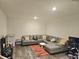 Spacious basement area with modern sectional, stylish rug, and wood-look flooring at 1297 Ascot Ter, Atlanta, GA 30329
