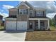Charming two-story home with brick facade, black shutters and a two-car garage at 1613 Fuma Leaf Way, Mcdonough, GA 30253