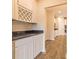 Modern kitchen with white cabinets, granite countertops, and a wine rack at 1613 Fuma Leaf Way, Mcdonough, GA 30253