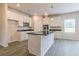 Bright kitchen with white cabinets, granite countertops, island with sink, and modern fixtures at 1613 Fuma Leaf Way, Mcdonough, GA 30253