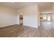Open concept living room with wood-look flooring and view to the kitchen and dining area at 1613 Fuma Leaf Way, Mcdonough, GA 30253