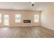 Bright living room featuring hardwood floors, a fireplace, and large windows at 1613 Fuma Leaf Way, Mcdonough, GA 30253