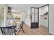 Open dining room with modern light fixtures and decor adjacent to kitchen, and a unique metal-framed door at 3512 Hidden Acres Drive, Atlanta, GA 30340