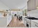 Modern open kitchen with stainless appliances, white cabinets, and a breakfast nook overlooking the open concept living area at 3512 Hidden Acres Drive, Atlanta, GA 30340