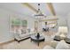 Bright living room featuring vaulted ceilings, wooden beams, and an open layout leading to the modern kitchen at 3512 Hidden Acres Drive, Atlanta, GA 30340