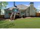 Back of house shows a well-maintained lawn with a deck and stairs leading down to the yard at 6252 Fernstone Trl, Acworth, GA 30101