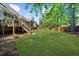 A well-manicured backyard with a lush lawn, mature trees, and a spacious deck with stairs at 6252 Fernstone Trl, Acworth, GA 30101