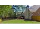 Expansive backyard with a lush lawn, mature trees, and a wooden deck with stairs to the house at 6252 Fernstone Trl, Acworth, GA 30101