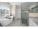 Bright bathroom featuring a garden tub, granite countertop, vanity, and a glass shower at 6252 Fernstone Trl, Acworth, GA 30101