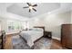 Cozy bedroom with tray ceiling, plantation shutters, and rich hardwood floors at 6252 Fernstone Trl, Acworth, GA 30101