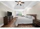 Bright bedroom features large TV, plantation shutters, and rich hardwood floors at 6252 Fernstone Trl, Acworth, GA 30101